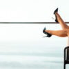 The beautiful legs of a woman lean against the railing