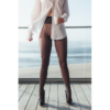 Schöne Frau steht mit einem Espresso auf dem Balkon. Sie trägt High Heels und Nylons.