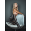 Eine schöne Frau sitzt mit Nylons in einem Sessel.
